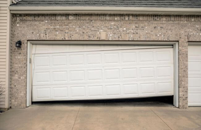 Damaged and misaligned garage door requiring urgent garage door repair in Melbourne by Garage Door Repair Guys.